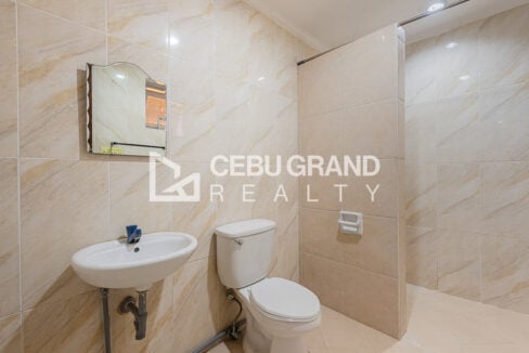 En-suite bathroom with marble-look tiles, a wall-hung sink and toilet