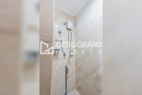 Shower with a water heater against marble-look tiles