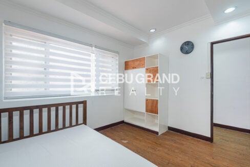 Bedroom with a wooden bed and a white-and-wood cubby wardrobe