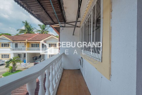 Upstairs balcony with white balusters overlooking neighbouring townhouses