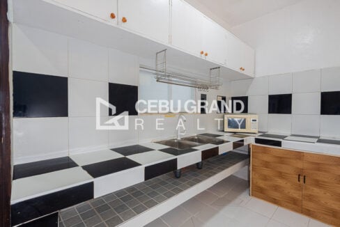Kitchen in the Banilad Town unit with black-and-white tiled counters and a double sink