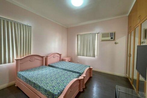 Bedroom with full-height mirrored wardrobes and wood-look flooring