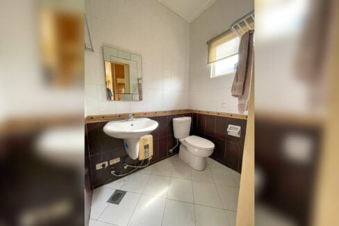 Bathroom with a pedestal basin, framed mirror and electric water heater