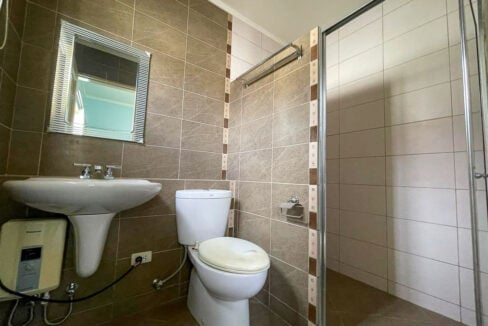 Bathroom with stone-look wall tiles and a glass shower