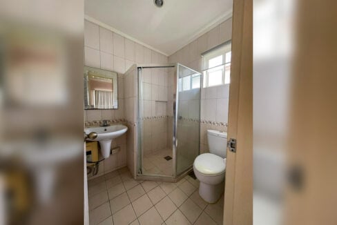Casa Rosita bathroom with a corner glass shower enclosure and window