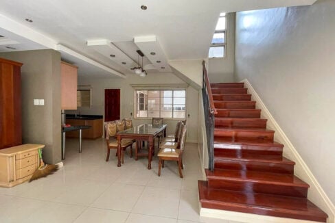 Dining area beside the staircase with polished wood treads