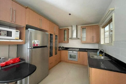 Kitchen with wood-grain cabinets, black granite counters, built-in oven and chimney hood