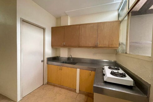 Service kitchen with a stainless counter, sink and overhead cabinets