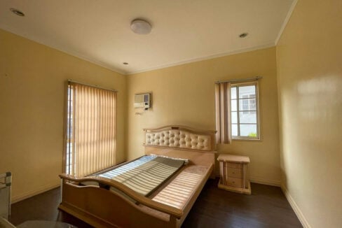 Bedroom in the Banawa house with vertical blinds and window-type air conditioning