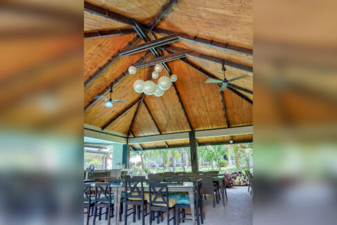 Restaurant pavilion with a vaulted timber ceiling, globe pendants and ceiling fans