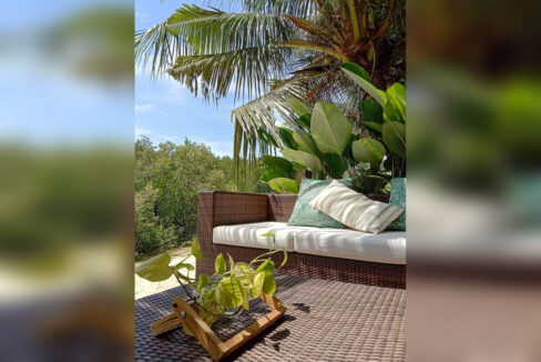 Wicker sofa with cushions facing the mangroves and open sky
