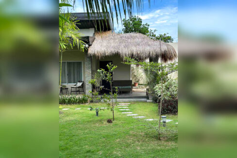 Guest room with a thatched-roof porch and garden path
