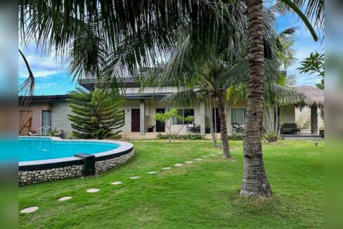 Curved swimming pool on a river-stone base beside the guest rooms and coconut palms