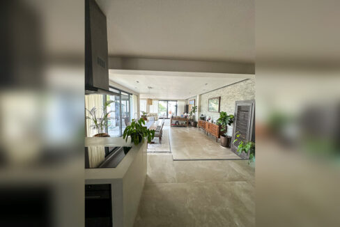 Open-plan kitchen, dining and living hall with stone-look floor tiles