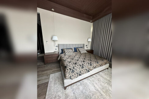 Master bedroom with a timber coffered ceiling and upholstered bed
