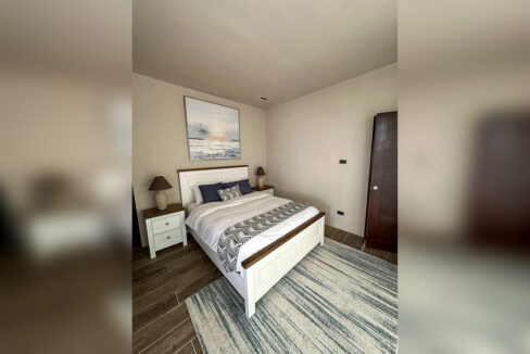 Guest bedroom with a white panel bed and wood-look floor