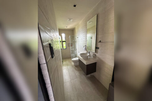 Bathroom with wave-pattern wall tiles, vessel sink and glass shower
