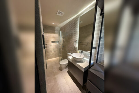 Bathroom with a backlit mirror, vessel sink and rain shower