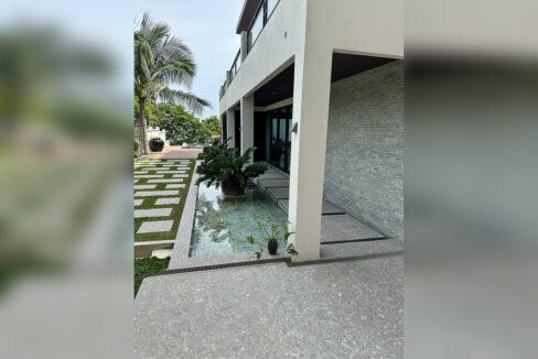 Reflecting pool with stone slabs running beneath the covered terrace