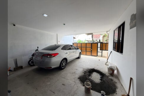 Covered ground-floor garage with a parked car and a motorcycle