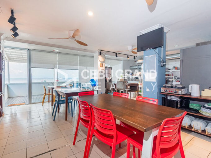 Dining hall with long tables and glass doors to the sea-view veranda