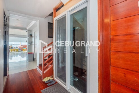 Entry hall with wood flooring, staircase and glass sliding door