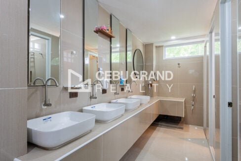 Shared bathroom with four vessel sinks and long mirrors