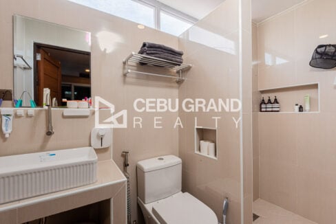 Bathroom with a ribbed basin, toilet and glass shower partition