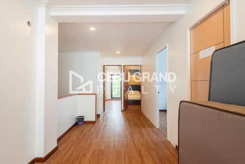 Upper-floor hallway with wood-look floors leading to the guest rooms