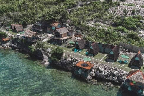 Thatched A-frame huts and stilt cottages above clear turquoise water