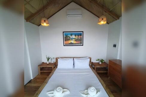 Guest room with a bamboo bed, rattan pendant lamps and split-type air conditioning
