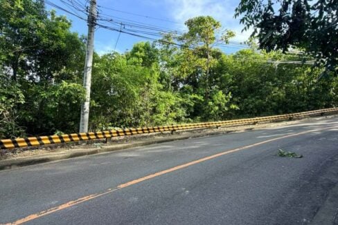 Sloping road along the elevated Maria Luisa lot, lined with a yellow-and-black guardrail