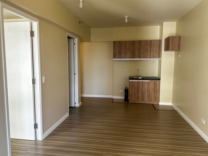Living area with wood-look flooring and kitchenette in a brand-new 1BR condo at Avida Riala Tower 5