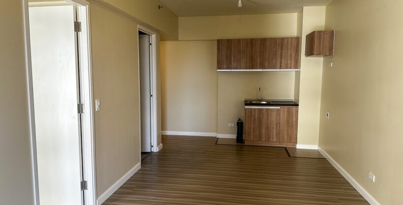 Living area with wood-look flooring and kitchenette in a brand-new 1BR condo at Avida Riala Tower 5