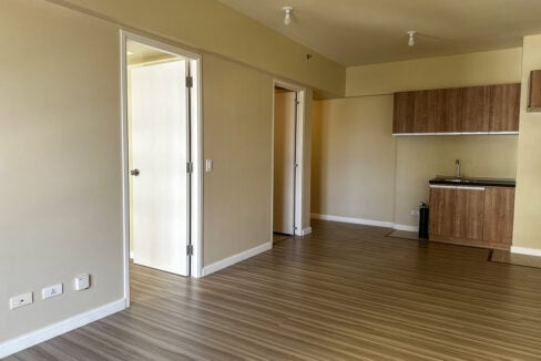 Open living area with bedroom door and kitchenette