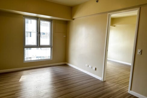 Bedroom with tall casement window and doorway to the living area