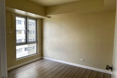 Bedroom with wood-look flooring and casement window