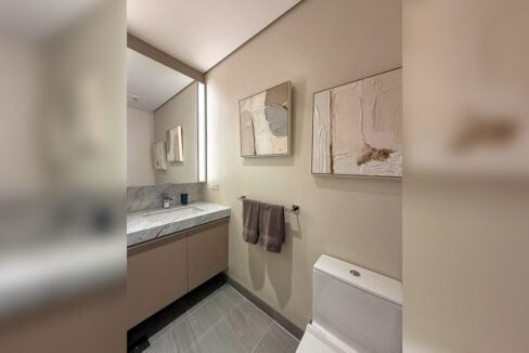 Powder room with marble vanity and framed art
