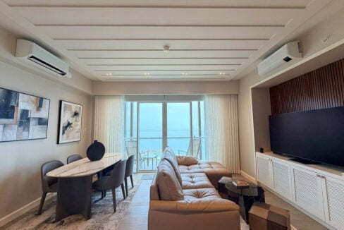Living and dining area opening to a sea-view balcony
