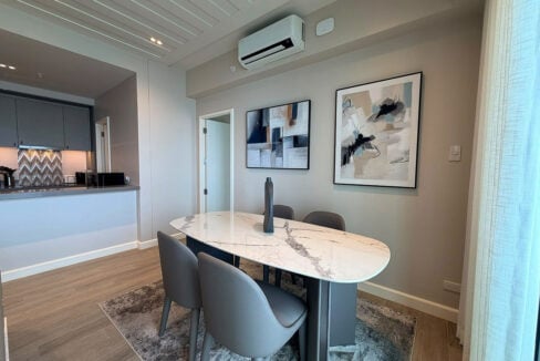 Marble-top dining table with upholstered chairs and abstract art