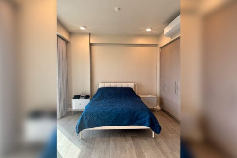 Bedroom with an upholstered headboard, white bedside cabinets and a floor-to-ceiling wardrobe