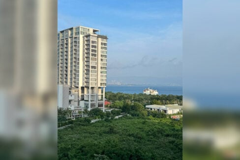 View over greenery and the water toward the Cebu mainland skyline from Aruga Resort and Residences