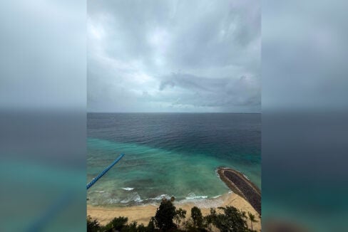Wide view of the open sea, breakwater and beach from the 18th floor