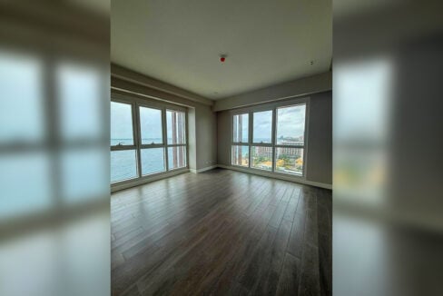 Corner bedroom with tall windows facing the sea and the coast