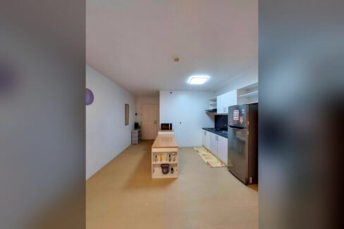 Wood-top kitchen island with open shelving beside the kitchen counter in the Avida Tower 2 unit