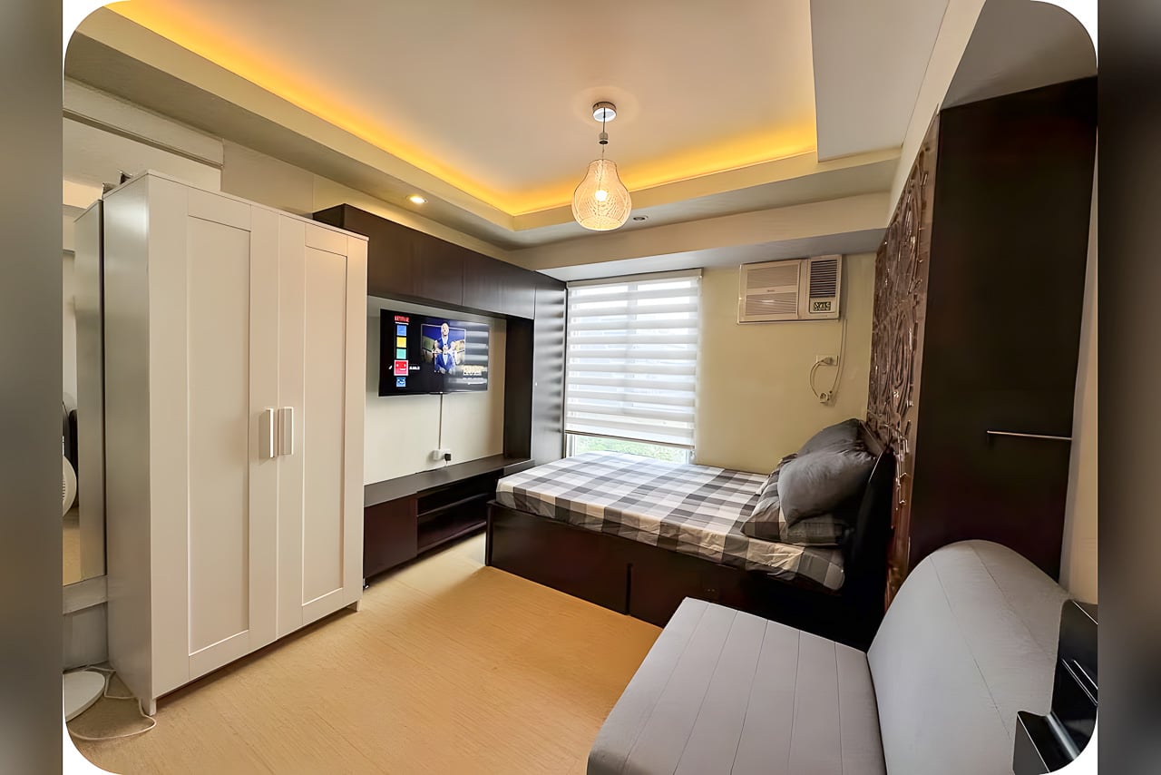 Furnished studio condo for sale at Avida Tower 2 with bed, TV wall, wardrobe and cove-lit ceiling