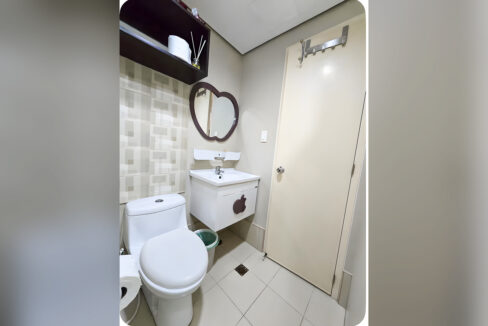 Bathroom with white vanity, decorative mirror, wall shelf and toilet
