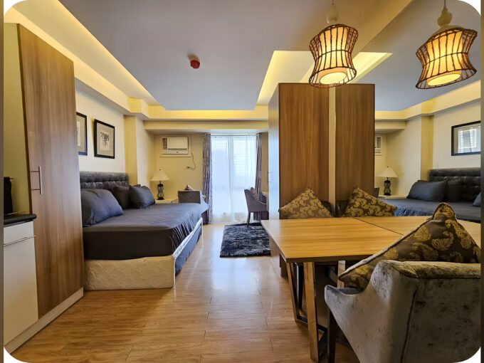 Furnished studio for sale at Avida Tower 1 with two beds, wardrobe divider, dining table and rattan pendant lamps