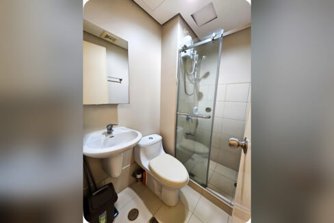 Bathroom with pedestal sink, mirror, toilet and sliding glass shower