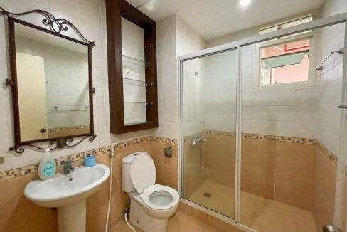 Bathroom with a pedestal basin, wrought-iron mirror and glass shower